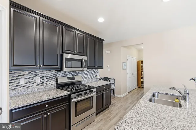 a kitchen with granite countertop stainless steel appliances and wooden cabinets