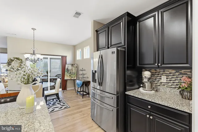 a kitchen with stainless steel appliances granite countertop a refrigerator and a sink
