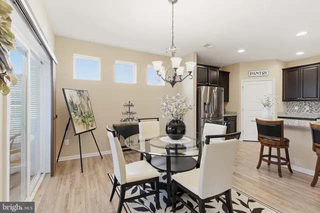 a view of a dining room with furniture a chandelier and wooden floor