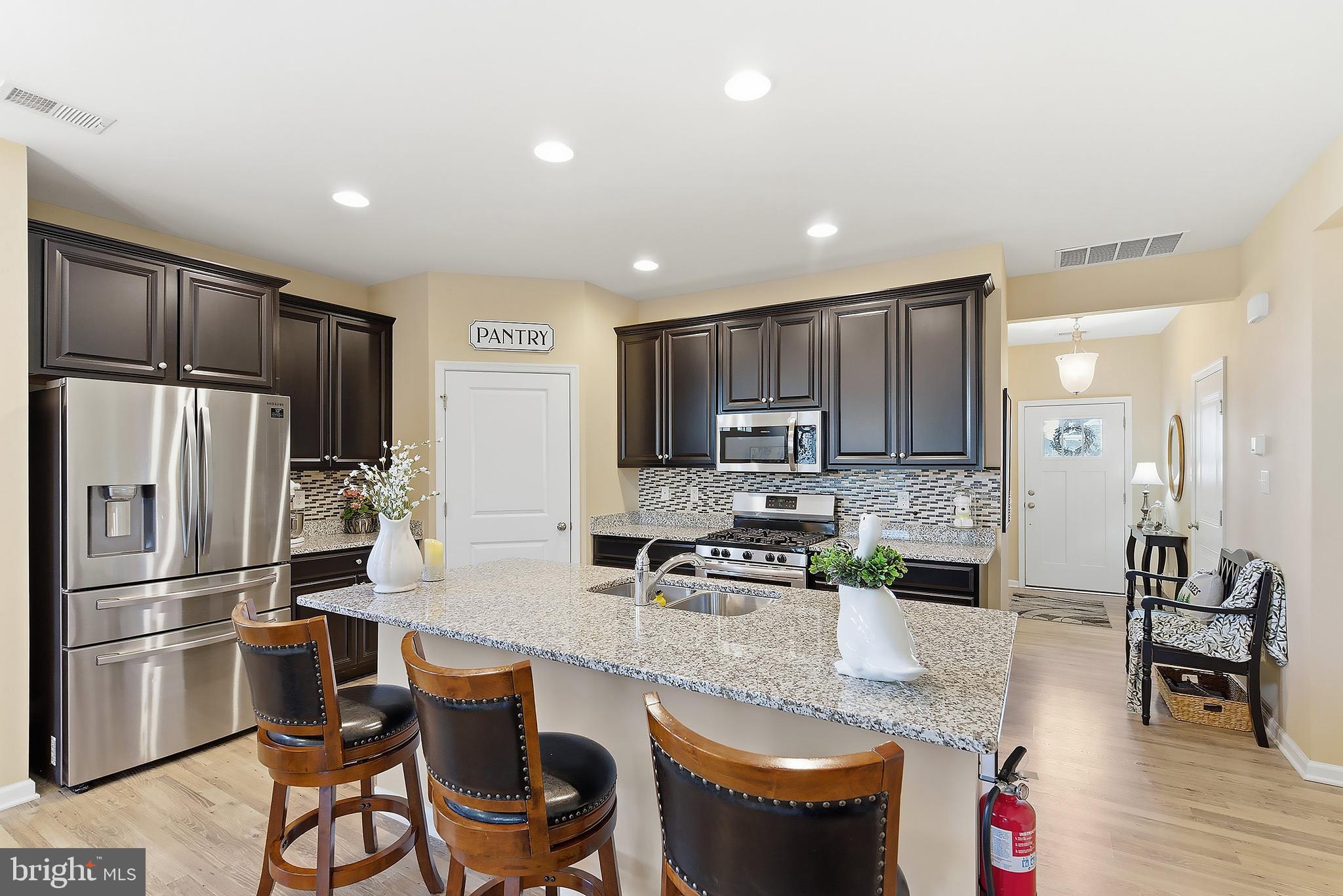 16 Raccoon Lane Barnegat, NJ 08005 - Photo 9 of 31 a kitchen with stainless steel appliances granite countertop a refrigerator a stove a sink a dining table and chairs with wooden floor