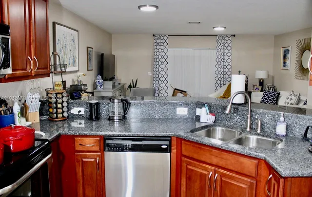 a kitchen with granite countertop a stove a microwave a sink and a counter top space