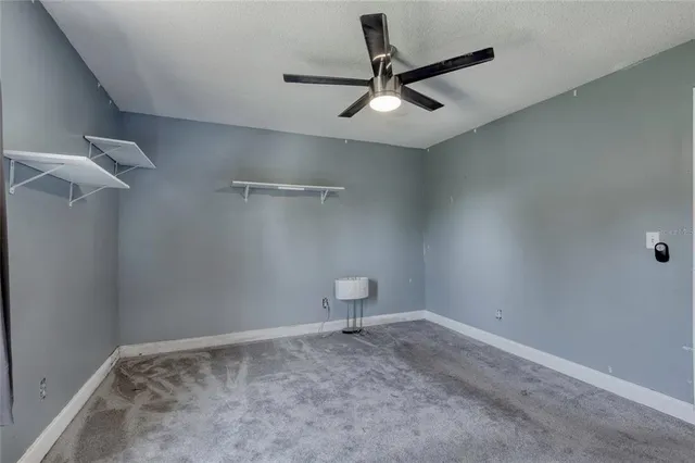 an empty room with a view of a ceiling fan and a window