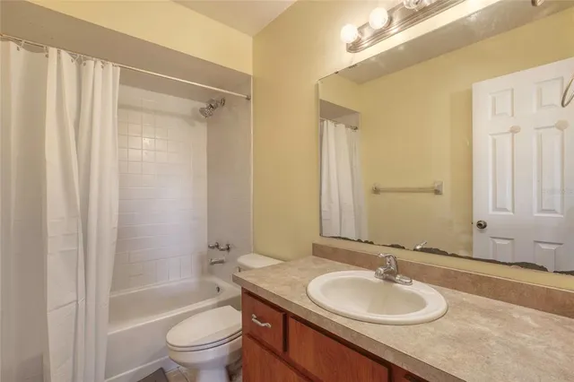a bathroom with a granite countertop sink toilet a mirror and shower