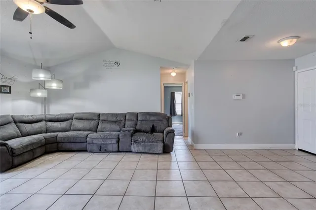 a living room with furniture and a ceiling fan