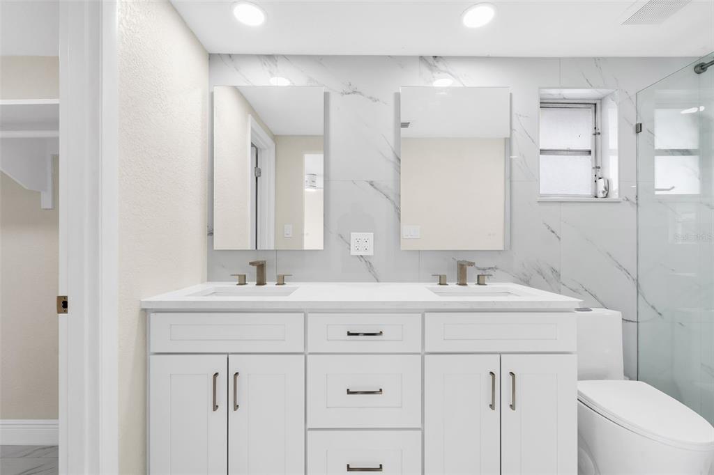 5626 Moog Road Holiday, FL 34690 - Photo 18 of 38 a bathroom with a double vanity sink mirror and toilet