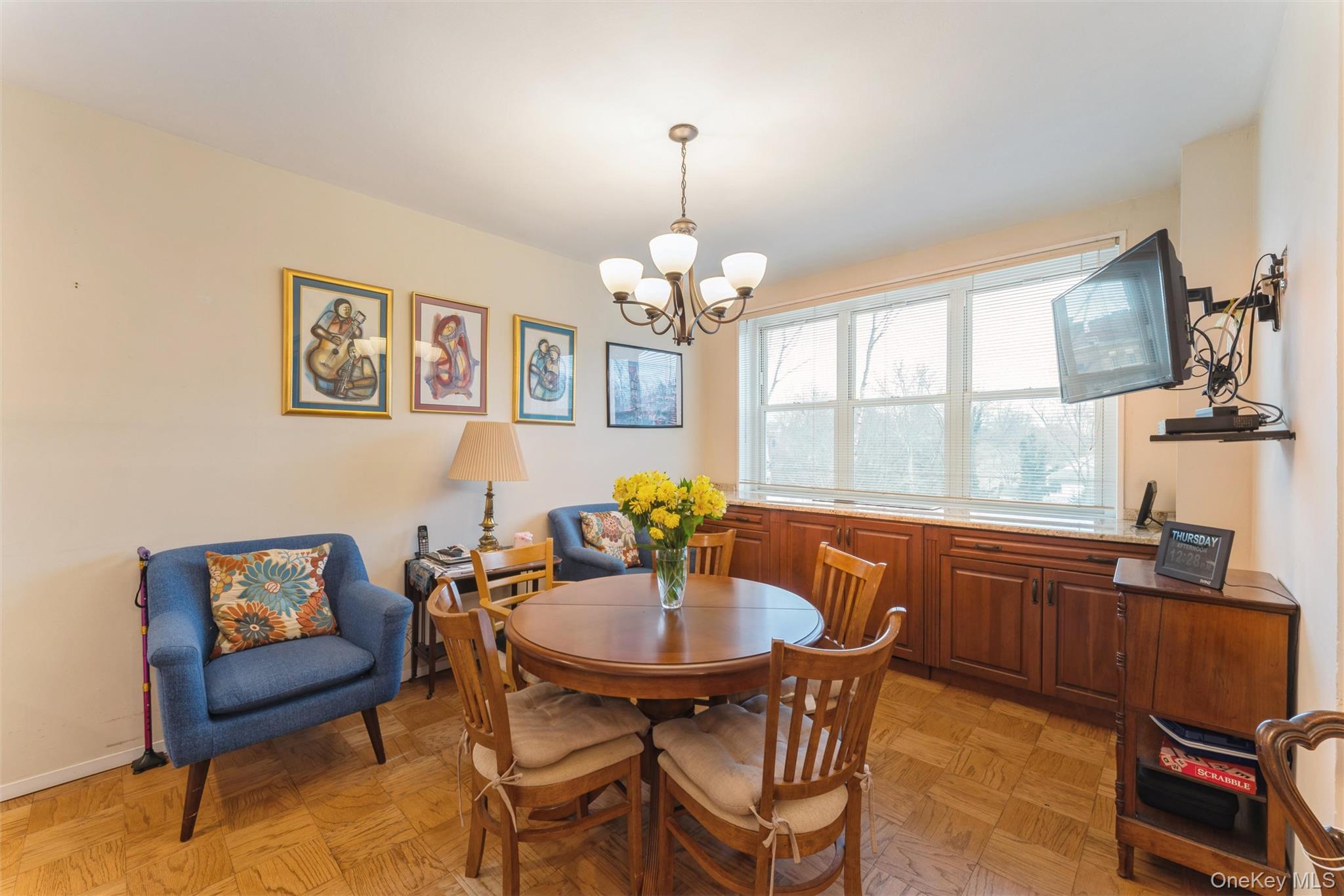 1 Kensington Gate, Unit PH9 Great Neck, NY 11021 - Photo 8 of 17 a dining room with wooden floor a chandelier a wooden table and chairs