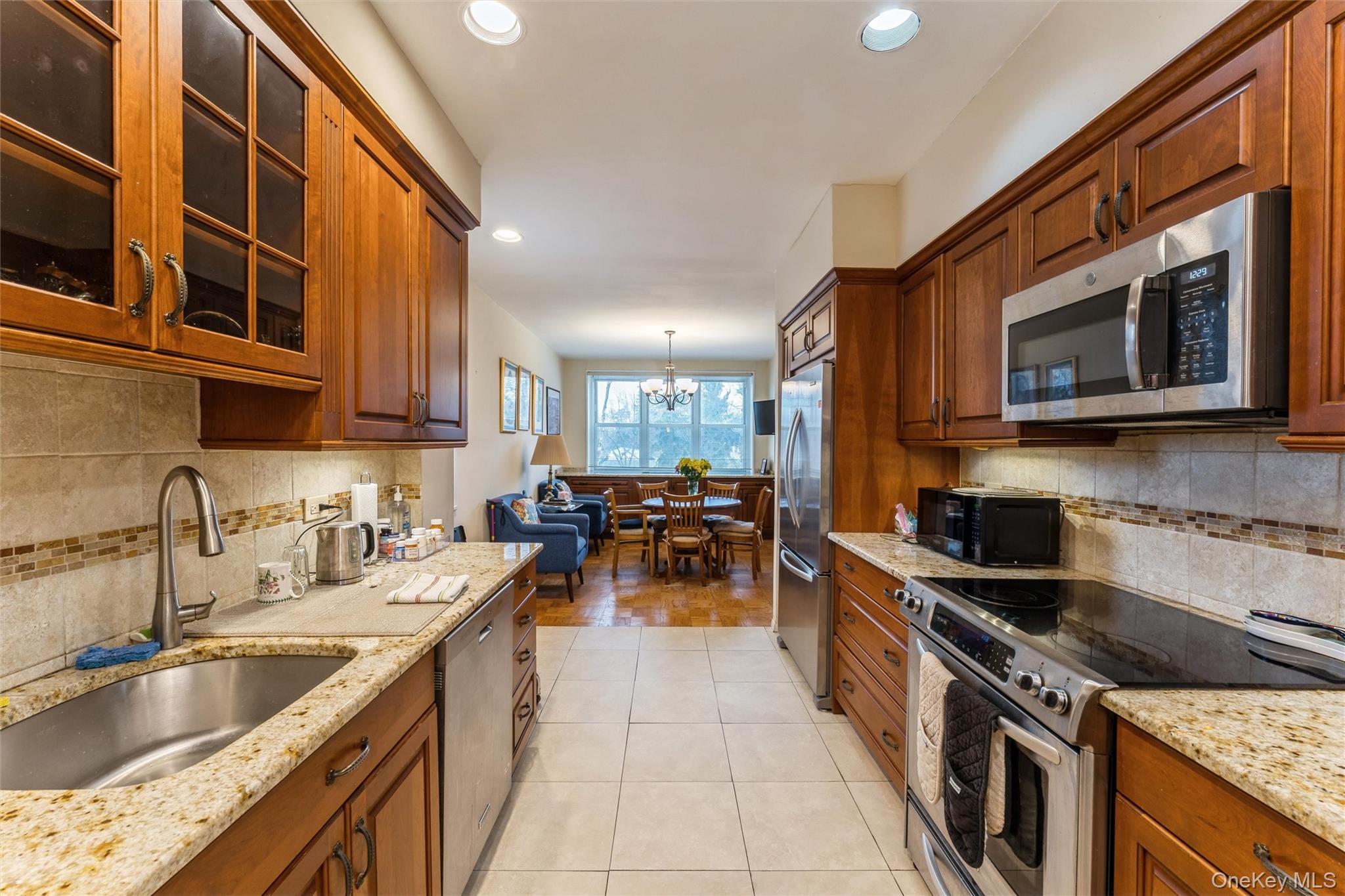 1 Kensington Gate, Unit PH9 Great Neck, NY 11021 - Photo 9 of 17 a kitchen with stainless steel appliances granite countertop a sink and a stove