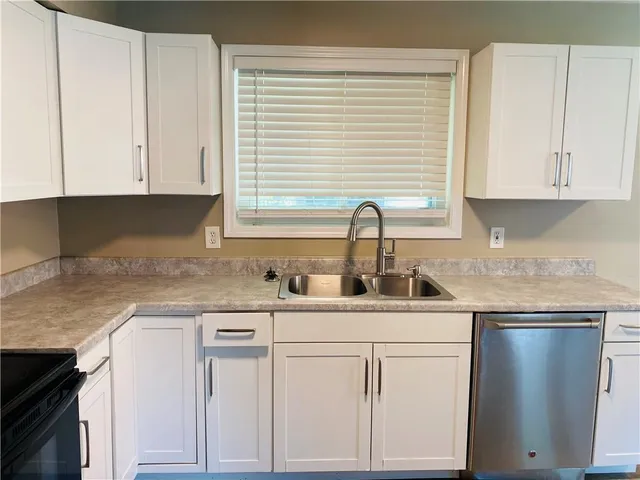 a kitchen with white cabinets and white appliances