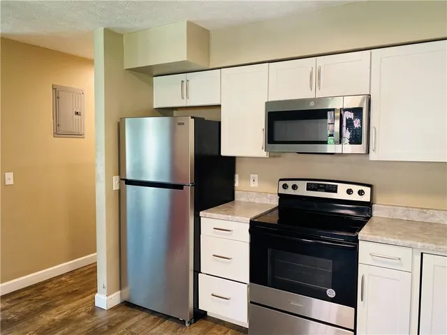 a kitchen with stainless steel appliances white cabinets white stove and a refrigerator