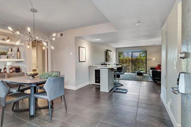 a living room with furniture a dining table a rug and kitchen view