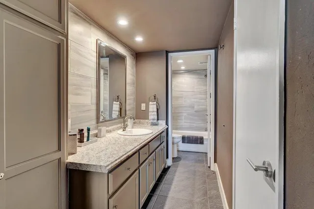 a bathroom with a granite countertop sink and a mirror