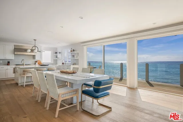 a kitchen with a dining table chairs and white cabinets