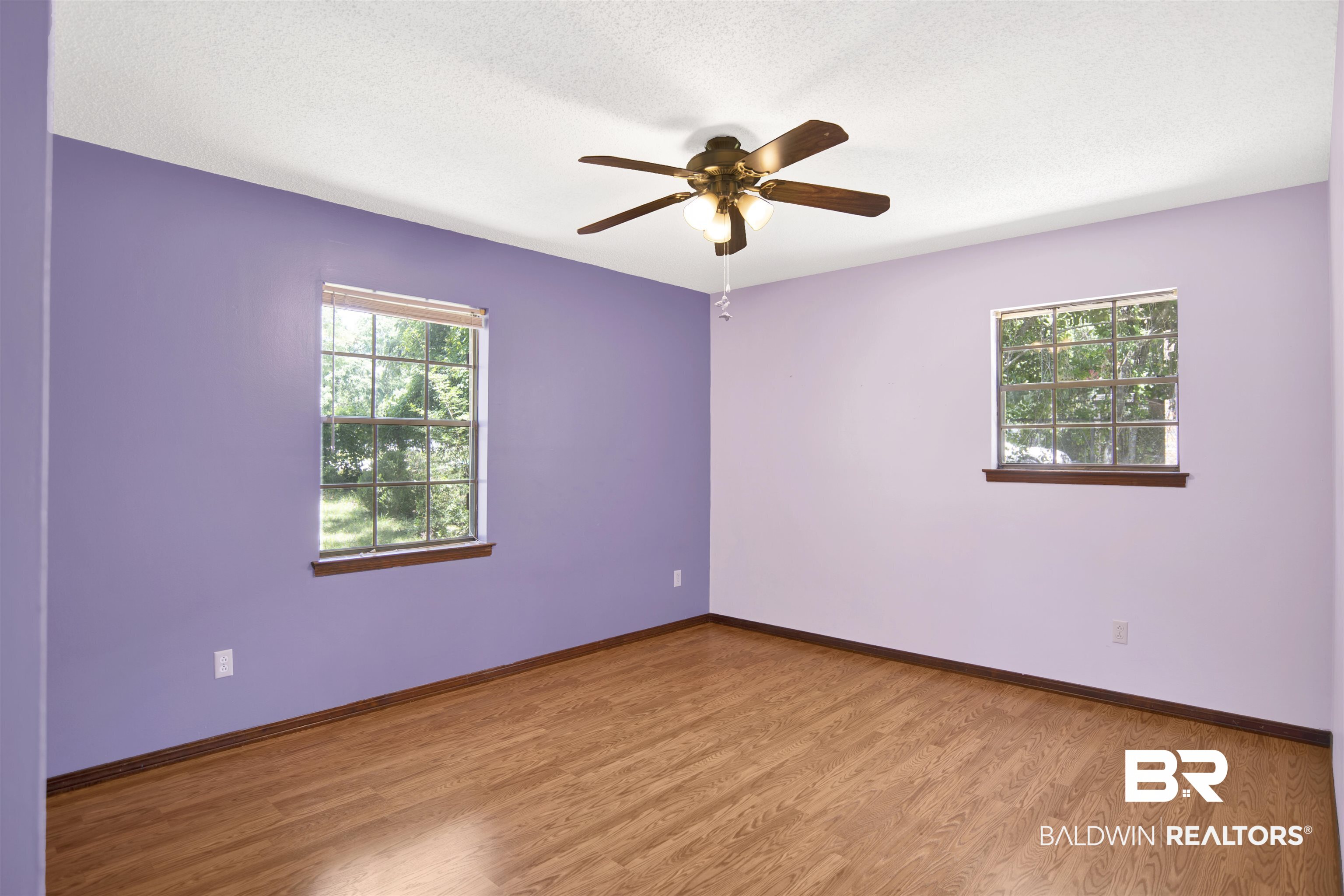30888 Cemetery Road Daphne, AL 36527 - Photo 22 of 36 Spacious room featuring wood-finish flooring, two large windows with horizontal blinds, a ceiling fan with integrated lighting, and a neutral ceiling