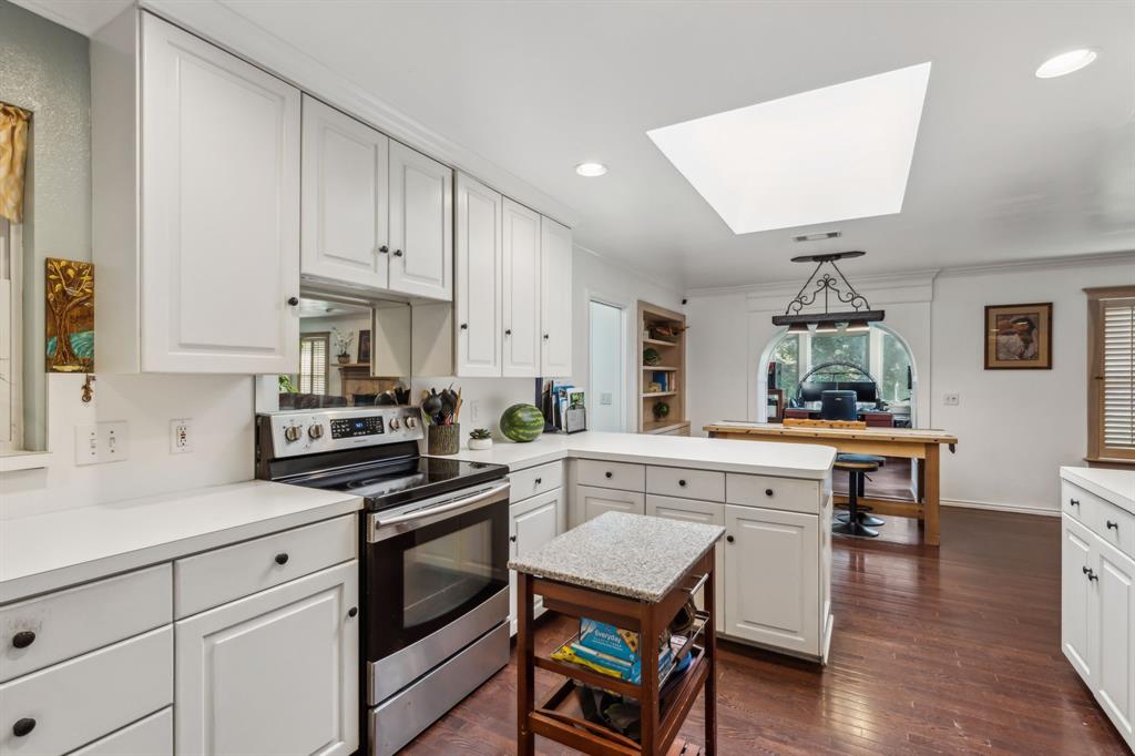 1980 Winningkoff Road Lucas, TX 75002 - Photo 15 of 35 White cabinetry with black hardware, stainless steel range, white countertops, wood-finish flooring, and a ceiling skylight