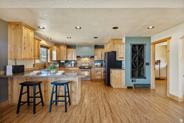 2013 North River View Road Huntsville, UT 84317 - Photo 12 of 53 Kitchen featuring light wood finish cabinets, a peninsula, light stone countertops, black appliances, and recessed lighting