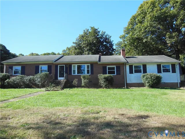 a front view of a house with a yard and trees