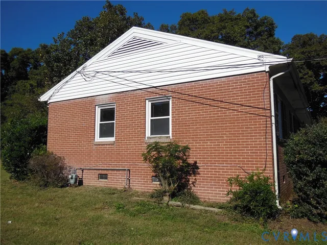 a white house with a small yard and a garden