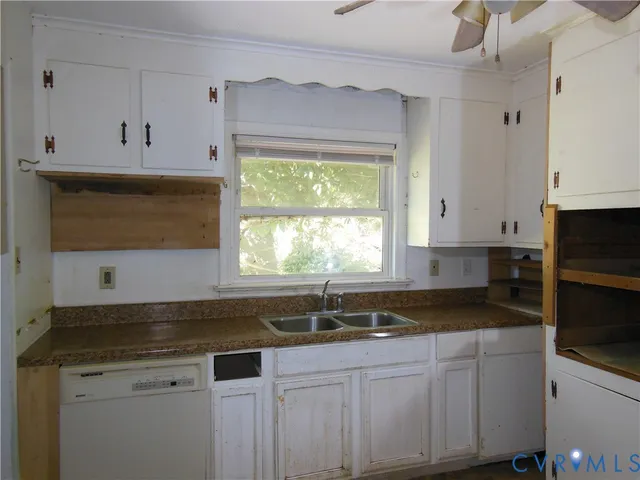 a kitchen with granite countertop a sink a stove and cabinets