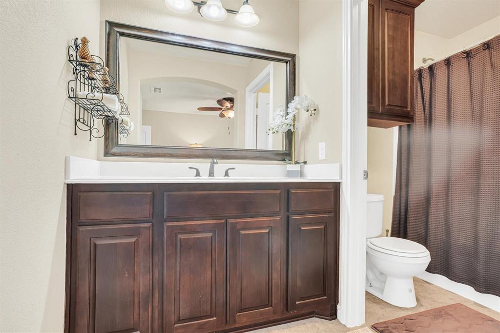14095 Pecan Lane Forney, TX 75126 - Photo 27 of 34 a bathroom with a sink a toilet and a mirror