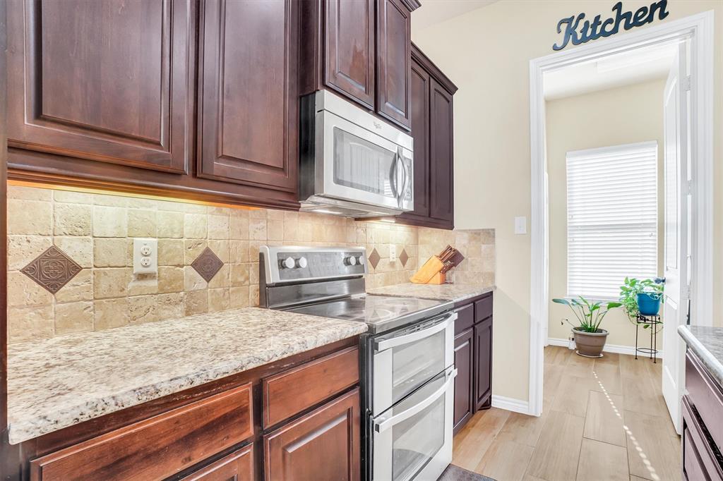 14095 Pecan Lane Forney, TX 75126 - Photo 4 of 34 a kitchen with granite countertop cabinets stainless steel appliances and a counter space