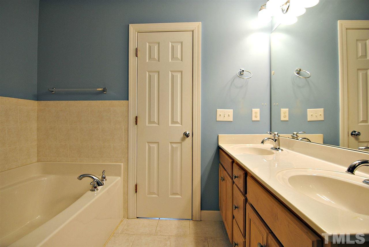 6924 Ray Road Raleigh, NC 27613 - Photo 15 of 22 a bathroom with a tub sink and mirror