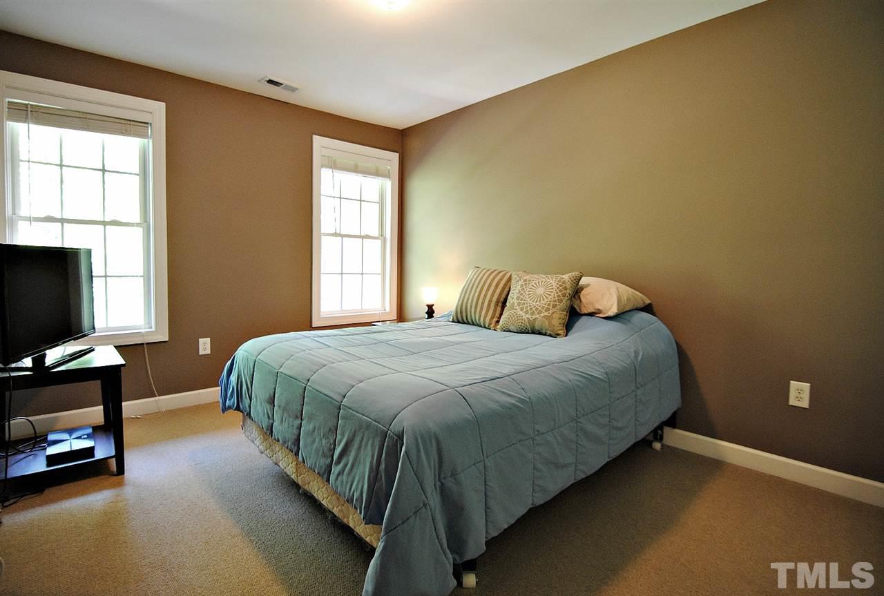 6924 Ray Road Raleigh, NC 27613 - Photo 16 of 22 a bedroom with a bed and a flat tv screen on the dresser