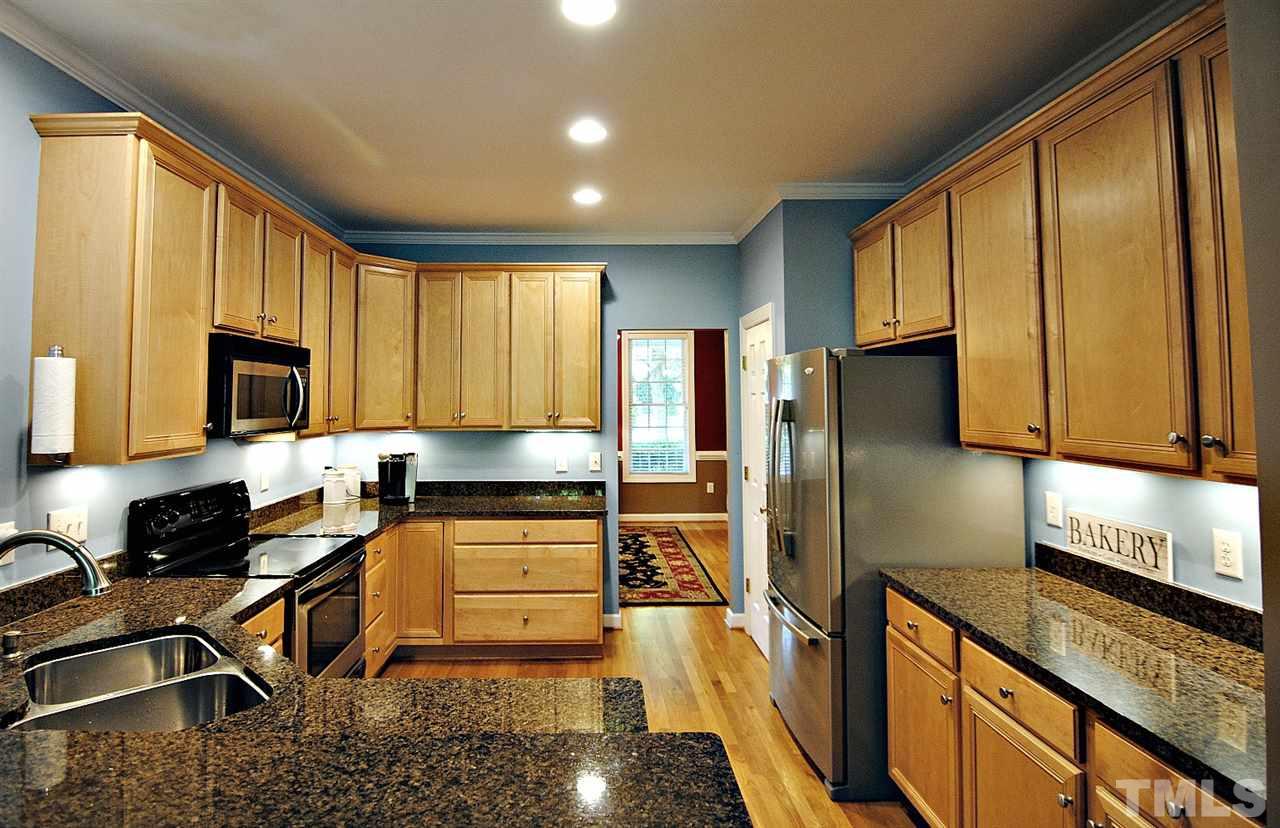 6924 Ray Road Raleigh, NC 27613 - Photo 8 of 22 a kitchen with stainless steel appliances granite countertop a stove a sink a refrigerator and cabinets