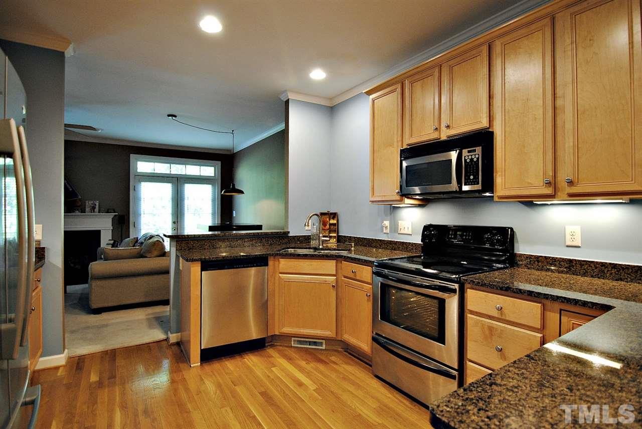 6924 Ray Road Raleigh, NC 27613 - Photo 10 of 22 a kitchen with stainless steel appliances granite countertop wooden cabinets a stove a sink and dishwasher