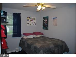 595 West County Line Road Hatboro, PA 19040 - Photo 8 of 11 a bedroom with a bed and a chandelier