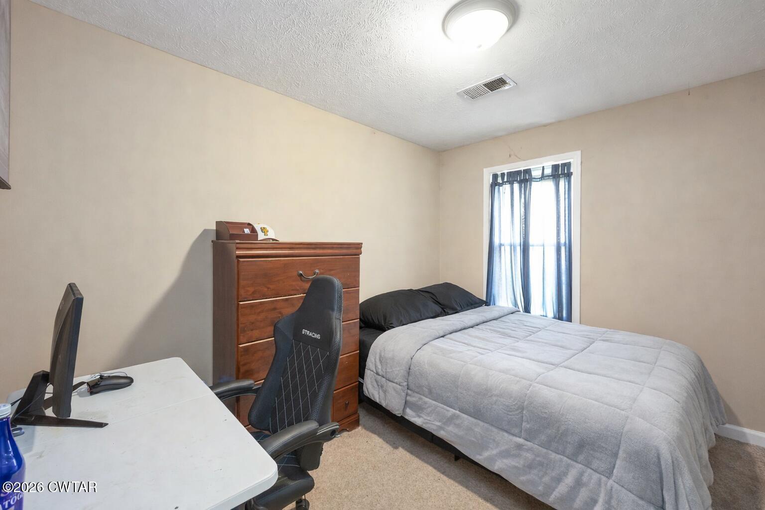 64 Ellendale Place Jackson, TN 38305 - Photo 13 of 19 a bedroom with a bed and a flat tv screen on the dresser