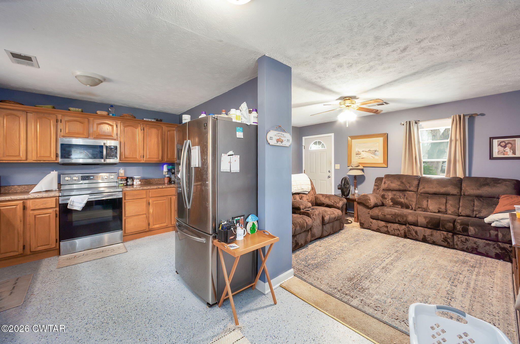 64 Ellendale Place Jackson, TN 38305 - Photo 4 of 19 a large open kitchen with stainless steel appliances kitchen island granite countertop a refrigerator a stove a sink a dining table and chairs with wooden floor