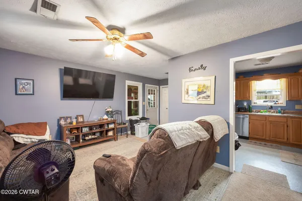 a living room with a bed furniture and a flat screen tv