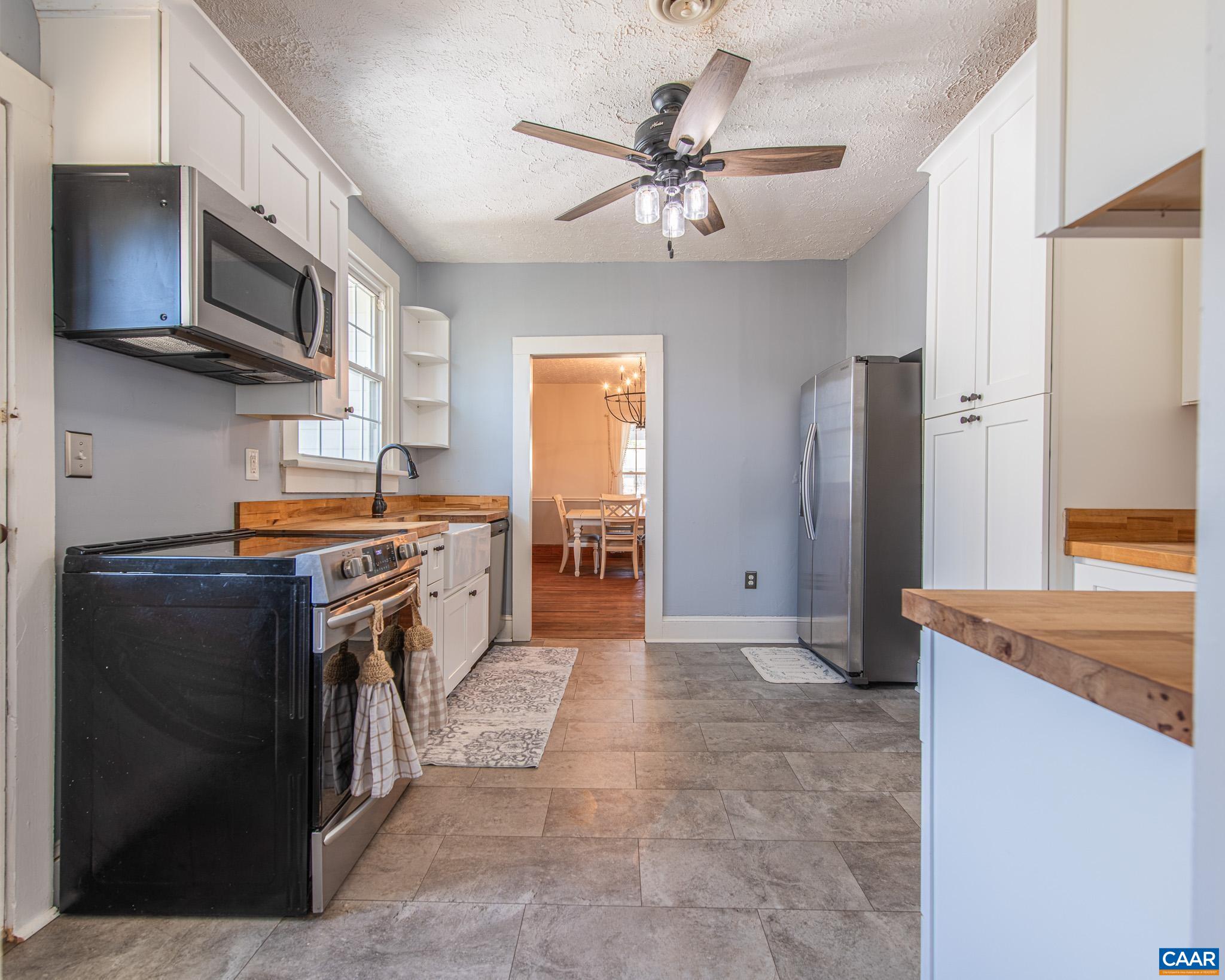 22 Quarter Lane Buckingham, VA 23921 - Photo 11 of 36 a kitchen with stainless steel appliances granite countertop a stove top oven a sink a refrigerator white cabinets and black appliances
