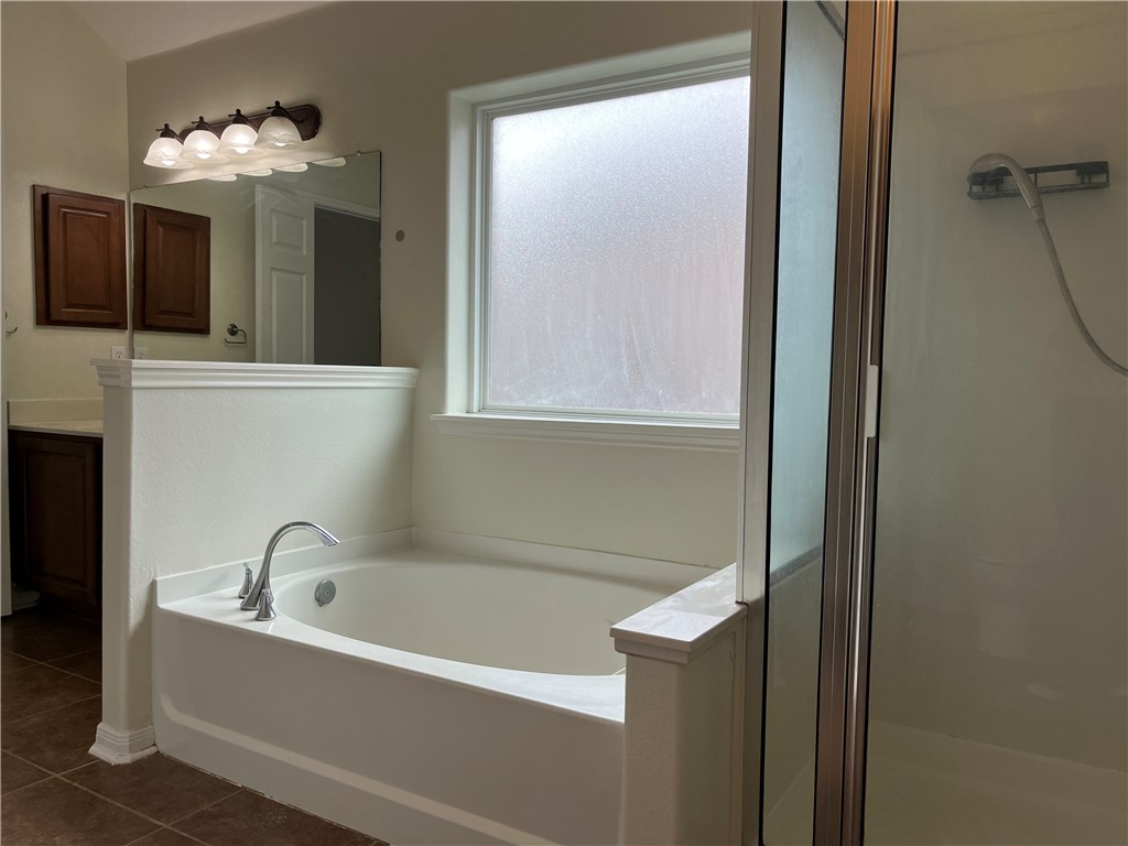 1406 Sacramento Street Portland, TX 78374 - Photo 14 of 35 a bathroom with a bathtub a mirror and a sink