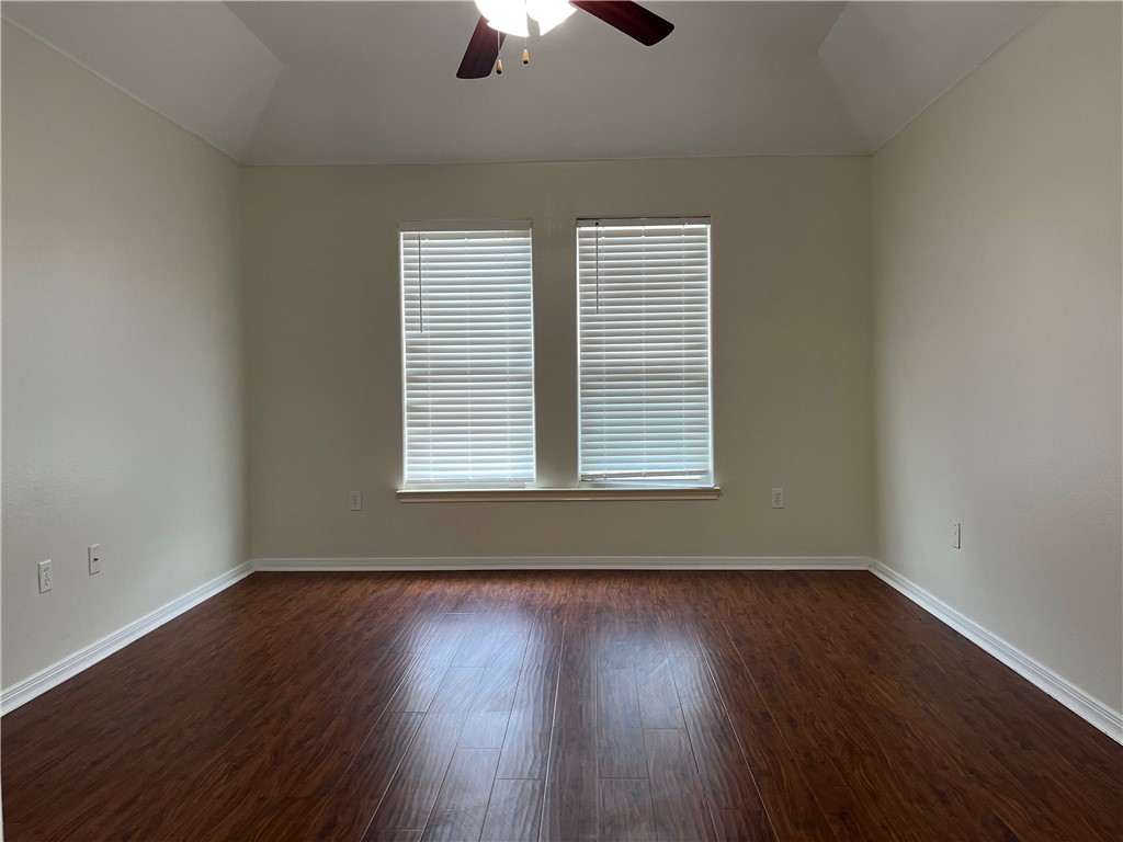 1406 Sacramento Street Portland, TX 78374 - Photo 10 of 35 an empty room with wooden floor chandelier fan and windows