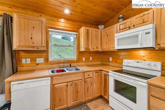 a kitchen with stainless steel appliances granite countertop a sink a stove and cabinets