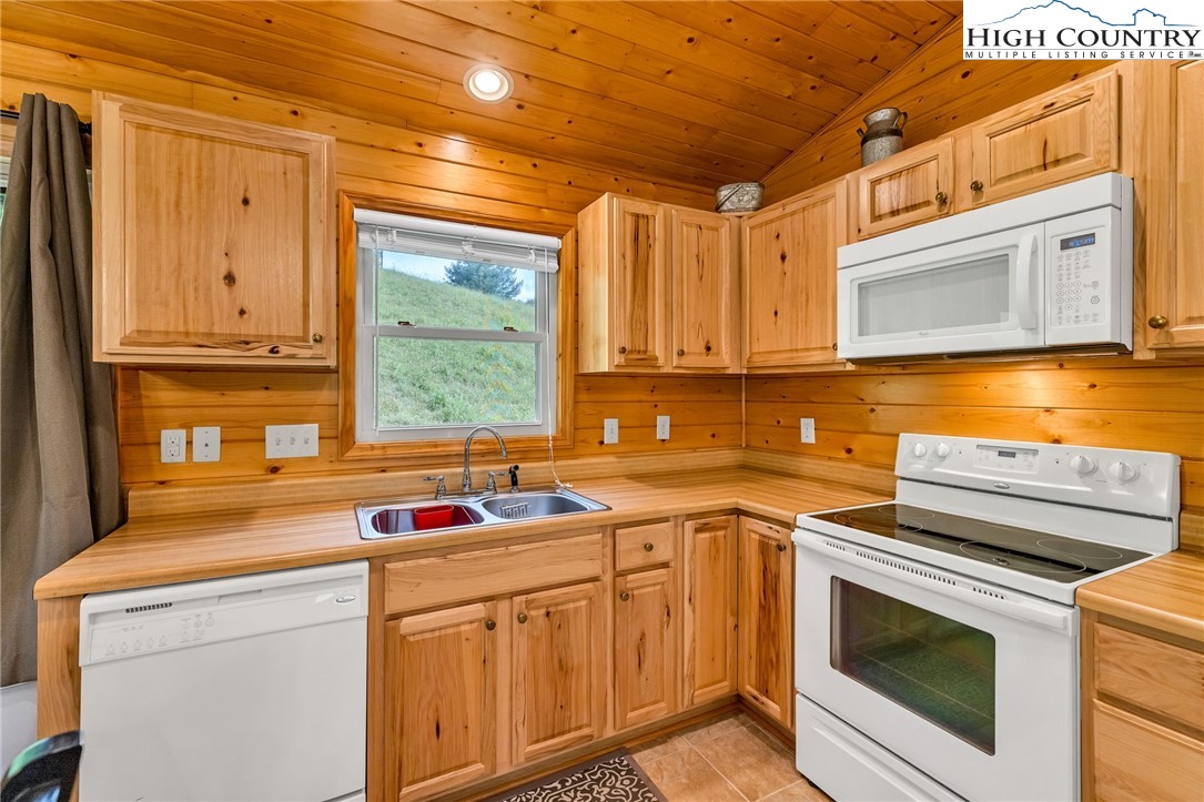 637 River Country Road Piney Creek, NC 28663 - Photo 14 of 49 a kitchen with stainless steel appliances granite countertop a sink a stove and cabinets