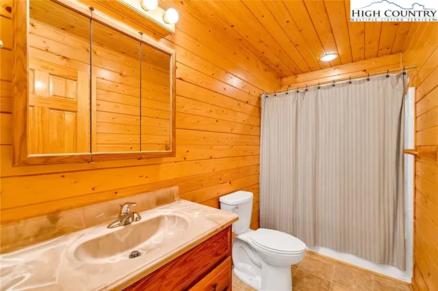 a bathroom with a sink a toilet and shower curtain