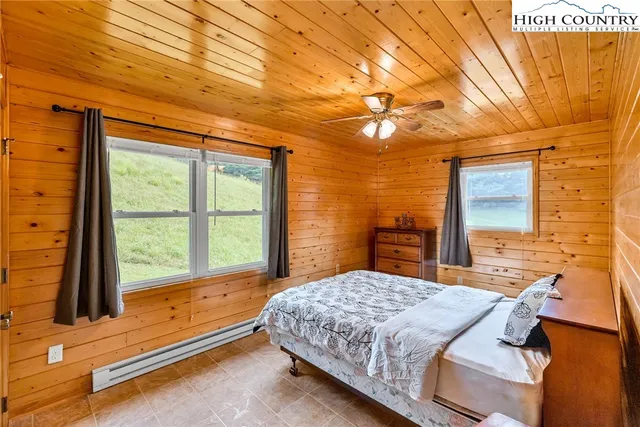 a bedroom with a bed and large windows