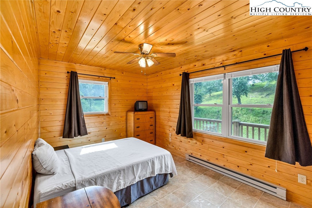 637 River Country Road Piney Creek, NC 28663 - Photo 20 of 49 a bedroom with a bed and wooden floor