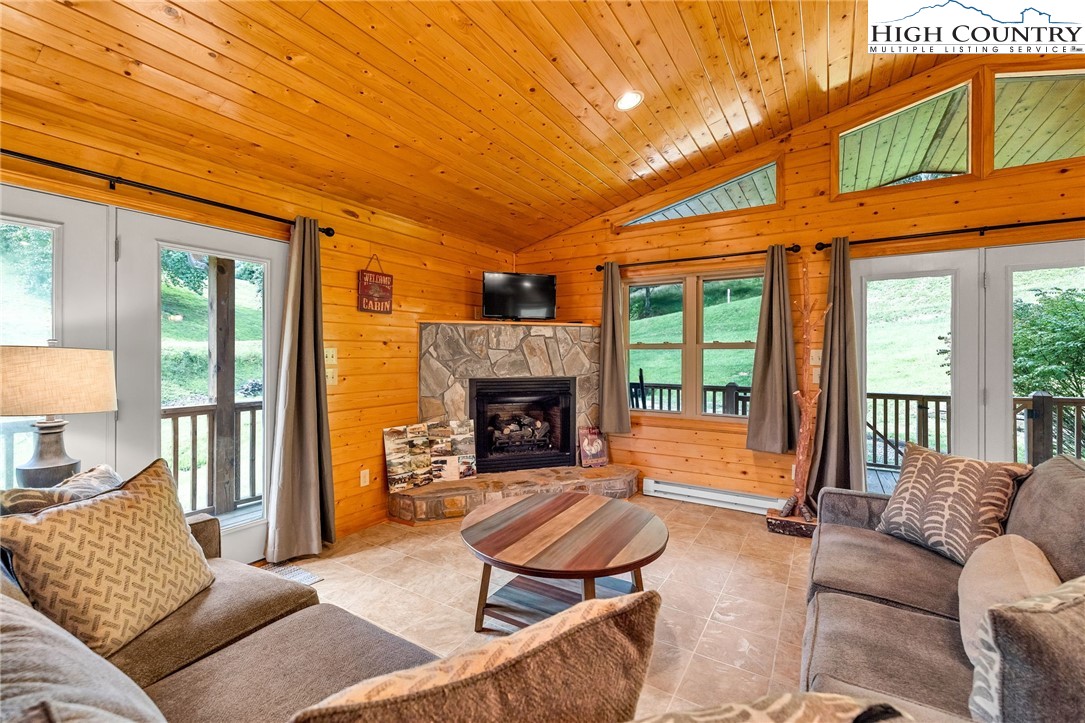 637 River Country Road Piney Creek, NC 28663 - Photo 2 of 49 a living room with furniture a fireplace and a table