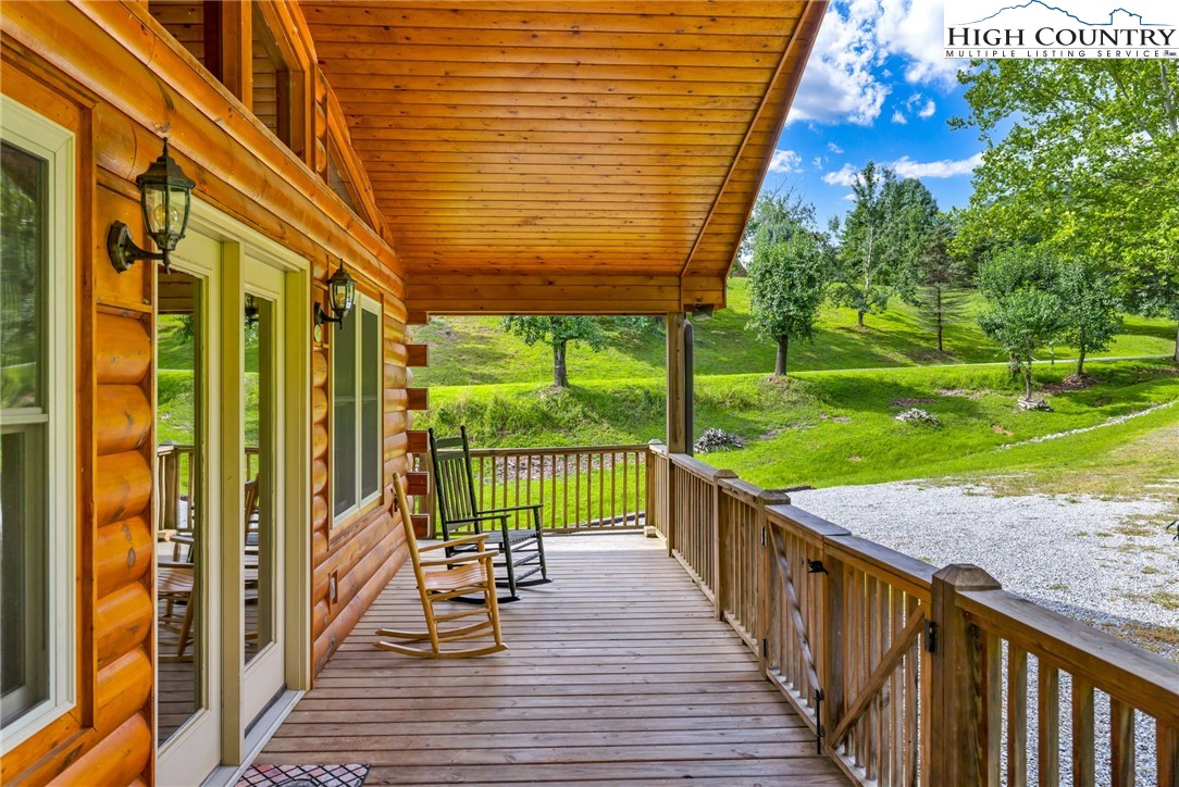 637 River Country Road Piney Creek, NC 28663 - Photo 24 of 49 a view of a porch with wooden floor and floor to ceiling window
