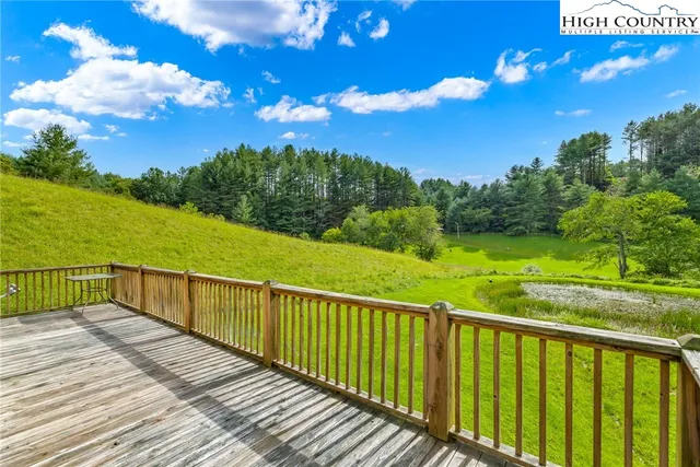 a view of a balcony with wooden floor & fence
