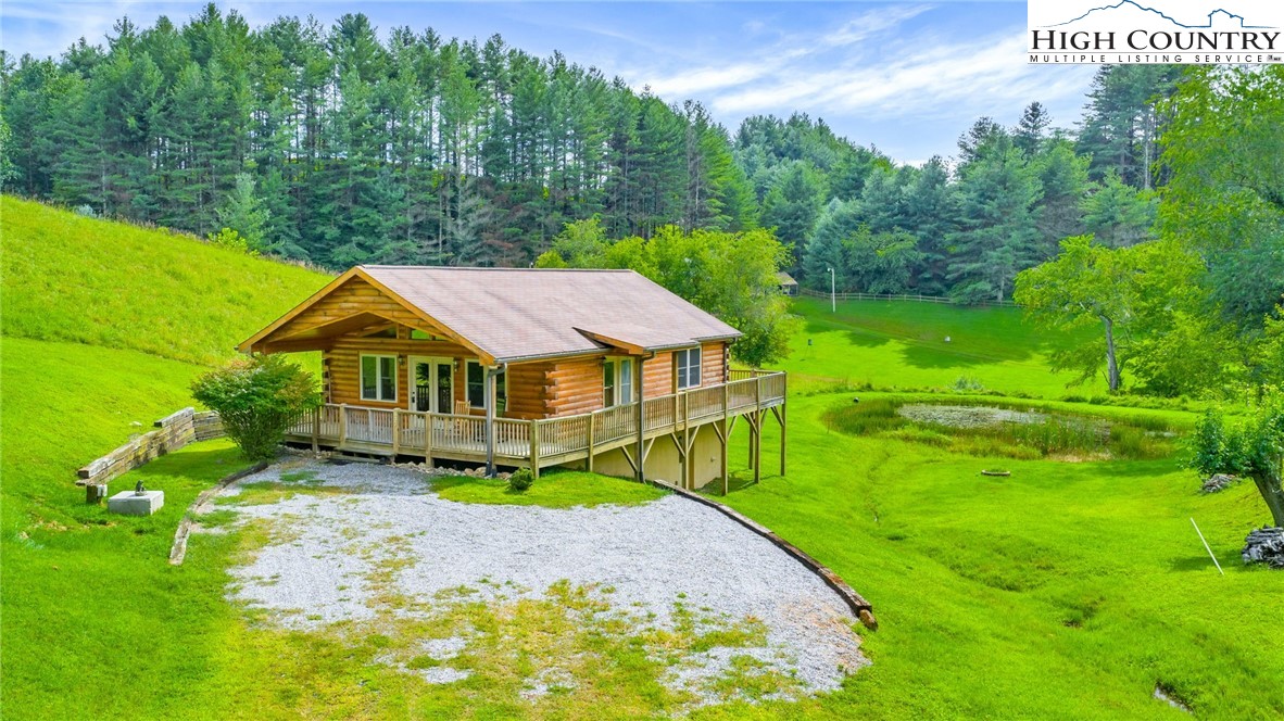 637 River Country Road Piney Creek, NC 28663 - Photo 37 of 49 a view of a big house with a big yard plants and large trees