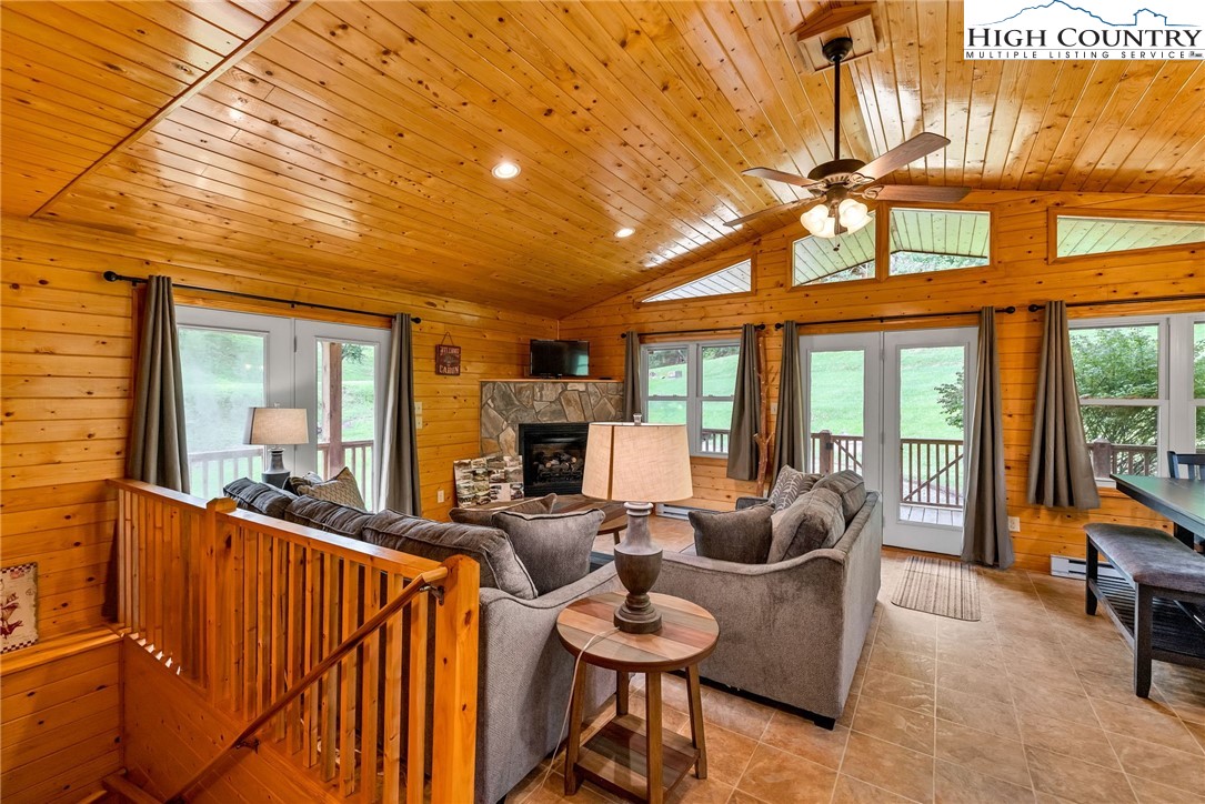 637 River Country Road Piney Creek, NC 28663 - Photo 4 of 49 a living room with furniture a flat screen tv and floor to ceiling window
