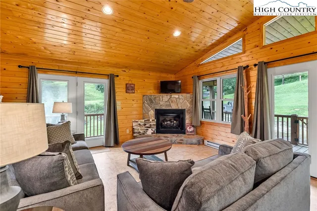 a living room with furniture a fireplace and a large window