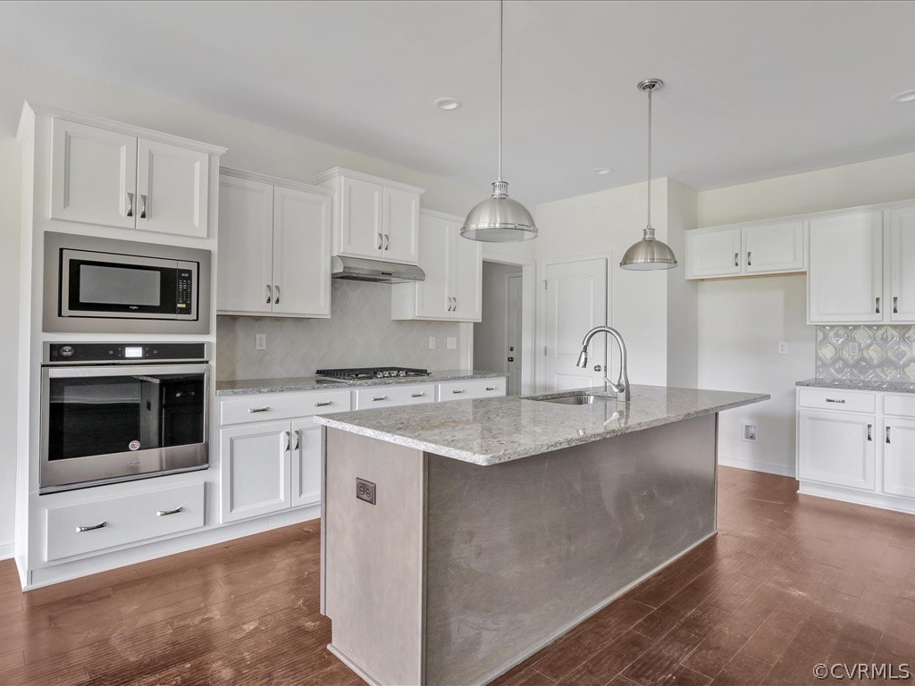 11673 Riverboat Drive Chester, VA 23836 - Photo 5 of 23 a kitchen with stainless steel appliances granite countertop a stove a sink and a microwave