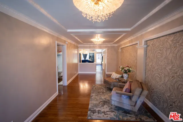 a bedroom with a bed and a dresser with wooden floor