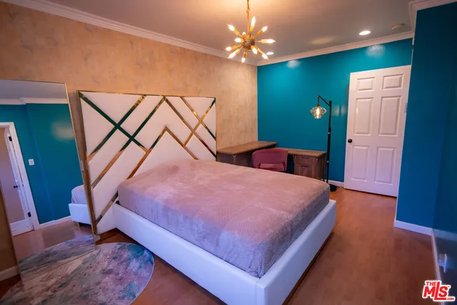 a bedroom with a bed and a chandelier