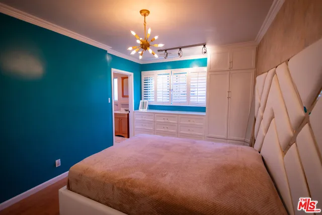 a kitchen with stainless steel appliances kitchen island granite countertop a refrigerator a stove a sink a dining table and chairs with wooden floor